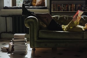 man in black jacket lying on white leather sofa chair
